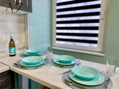 a table with plates and glasses and a bottle of wine at NJ Luxury rooms and suites in Varna City