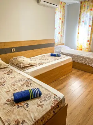 two beds in a room with wooden floors at Sozopol Apartment with Sea View in Sozopol