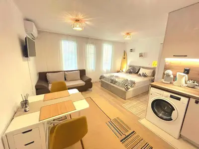 a living room with a couch and a bed in a room at Studio Aloha in Burgas City