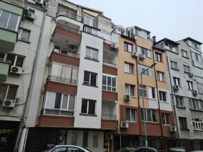 an apartment building in paris with cars parked in front at Studio Aloha in Burgas City