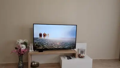 a flat screen tv sitting on a shelf in a living room at Sea Dreams Sunrise Apartment in Sveti Vlas