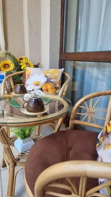 a glass table with two chairs and a table with cups on it at Sea Dreams Sunrise Apartment in Sveti Vlas