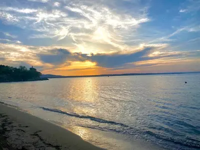 a sunset over a body of water with a beach at AJ Apartment 2, Santa Marina Holiday Village, Sozopol in Sozopol