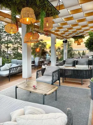a patio with couches and tables and chandeliers at Summer Breeze Park Apartment, Santa Marina Holiday Village, Sozopol in Sozopol
