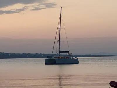 a boat floating on the water at sunset at Summer Breeze Park Apartment, Santa Marina Holiday Village, Sozopol in Sozopol