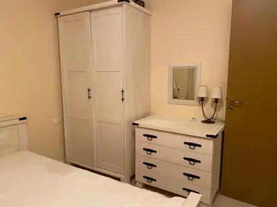 a bedroom with a white cabinet and a dresser at Summer Breeze Park Apartment, Santa Marina Holiday Village, Sozopol in Sozopol