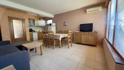 a living room with a couch and a table and a kitchen at Guest House Primorsko - Uzundzha in Primorsko