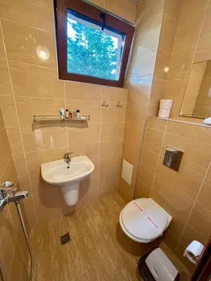 a bathroom with a sink and a toilet and a window at Guest House Primorsko - Uzundzha in Primorsko