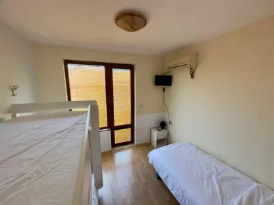 a white bedroom with a bed and a window at Guest House Primorsko - Uzundzha in Primorsko