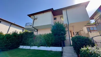 a house with a staircase in front of a yard at Guest House Primorsko - Uzundzha in Primorsko