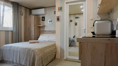 a small bedroom with a bed and a television at Varna Attic Studio - Варна Атик Студио in Varna City