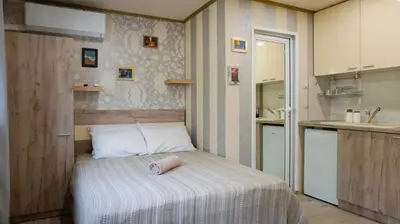 a small bedroom with a bed and a kitchen at Varna Attic Studio - Варна Атик Студио in Varna City
