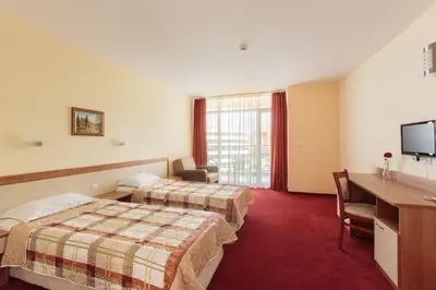 a hotel room with two beds and a desk at Hotel RIAGOR - ALL INCLUSIVE in Sunny Beach