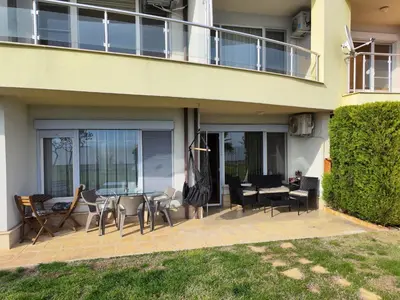 a patio with a table and chairs and a balcony at Alex Beach in Elenite