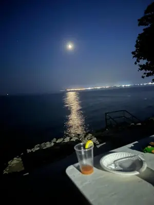 a table with a view of the ocean at night at Alex Beach in Elenite