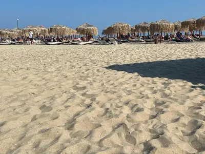 a sandy beach with chairs and umbrellas on it at Phoenix APARTMENT Апартамент Феникс in Sveti Vlas