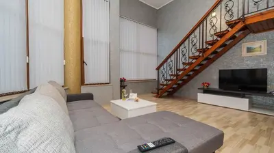 a living room with a couch and a television at Paradise Sarafovo Beach in Burgas City