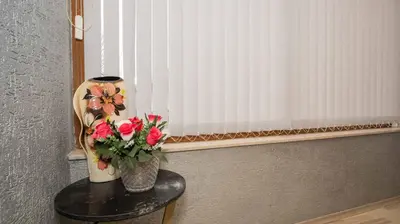 a vase of flowers on a table with a window at Paradise Sarafovo Beach in Burgas City