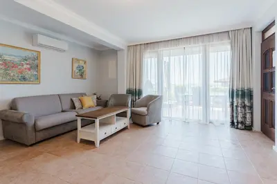 a living room with a couch and a table at Созопол Sozopol- SOZOPOLIS - MORE SUN 2В in Sozopol