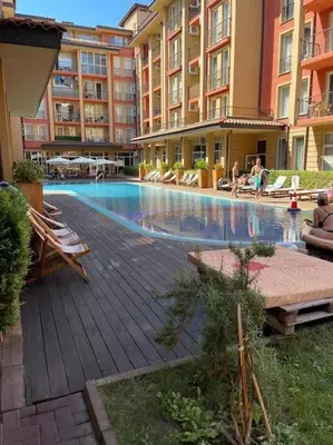 a large swimming pool in a building with people sitting around it at sunny view cacao beach in Sunny Beach