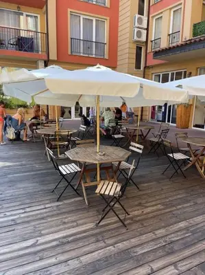 a group of tables and chairs with umbrellas on a patio at sunny view cacao beach in Sunny Beach