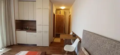 a kitchen with white cabinets and a table and a desk at sunny view cacao beach in Sunny Beach