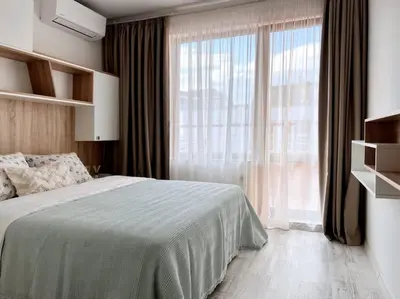 a bedroom with a bed and a large window at Seaside apartment Tyndzha in Pomorie