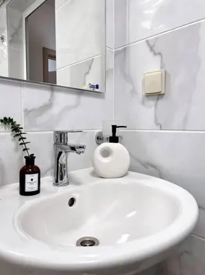 a white sink in a bathroom with a mirror at Seaside apartment Tyndzha in Pomorie