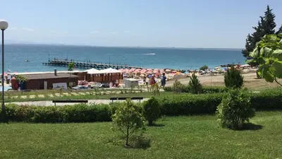 a beach with a bunch of umbrellas and a pier at Studio Apartment C32 in Dream Holiday Complex Ravda in Ravda