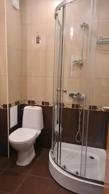 a bathroom with a toilet and a glass shower at Apartment Oasis A4 Kamchia in Bliznatsi