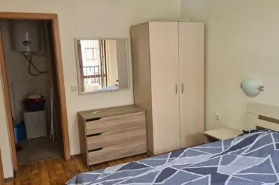 a bedroom with a bed and a dresser and a mirror at Apartment Oasis A4 Kamchia in Bliznatsi