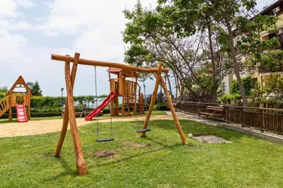 a park with a playground with a swing at Garden of Eden Sea and Pool View in Sveti Vlas