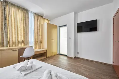 a hotel room with a bed and a tv at Paradise Apartments Primorsko in Primorsko