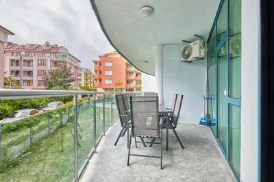 a balcony with chairs and a table on a building at Paradise Apartments Primorsko in Primorsko