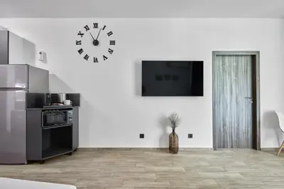a kitchen with a clock on a white wall at Paradise Apartments Primorsko in Primorsko