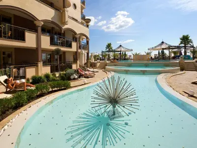 a swimming pool at a resort with a large blue pool at Hotel Golden Ina - All Inclusive - Beachfront in Sunny Beach