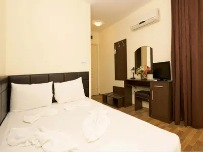 a bedroom with a bed and a desk with a mirror at Hotel Golden Ina - All Inclusive - Beachfront in Sunny Beach