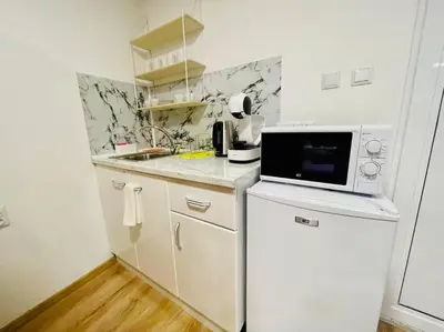 a small kitchen with a microwave and a refrigerator at Studio 21 in Varna City