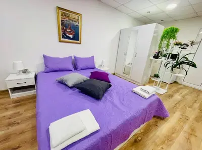 a purple bed with two pillows on it in a room at Studio 21 in Varna City