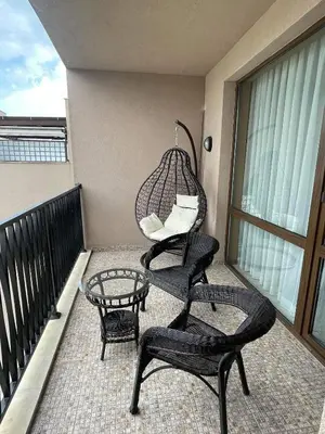 a porch with two chairs and a swing on a balcony at Z-apartment in Sunny Beach