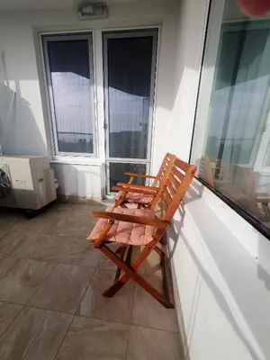 a wooden chair sitting on the side of a balcony at The Swing in Burgas City