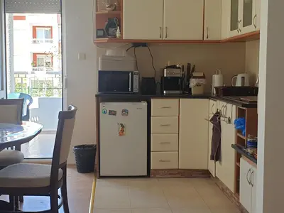 a kitchen with a white refrigerator and a table at Sunny Fort apartments Sanny Beach Parking Free in Sunny Beach