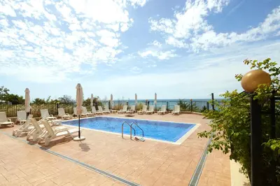 a pool with chaise lounge chairs and a resort at Mary Beach Resort Premium Apartments in Sveti Vlas