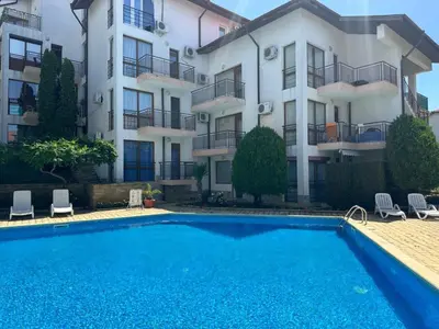 an apartment with a swimming pool in front of a building at Complex Compass in Sveti Vlas