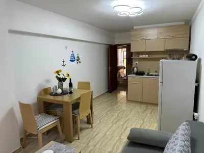 a kitchen and dining room with a table and a refrigerator at Complex Compass in Sveti Vlas