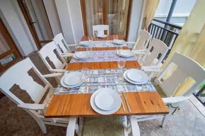 a wooden table with white plates and glasses on it at SeaRent Dream Home in Santa Marina - 2 bedrooms, 2 baths and a HUGE terrace in Sozopol