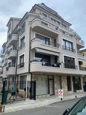a large white building with balconies on a street at Sea View Rooms Briz in Nesebar