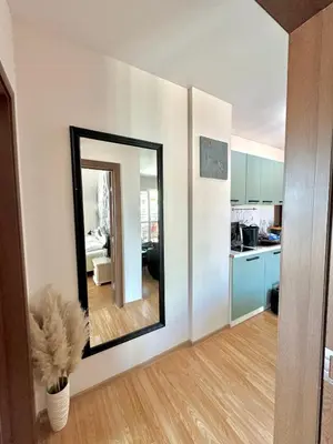 a living room with a mirror and a kitchen at Golden Hermes Apartments in Sunny Beach
