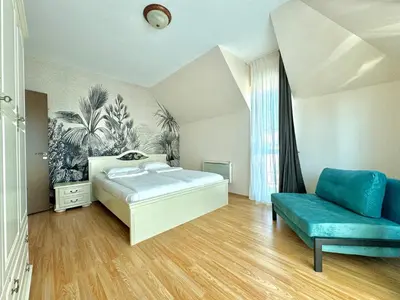 a bedroom with a bed and a blue couch at Golden Hermes Apartments in Sunny Beach