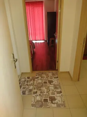 a hallway with a tile floor with a red curtain at Ред хаус in Sunny Beach